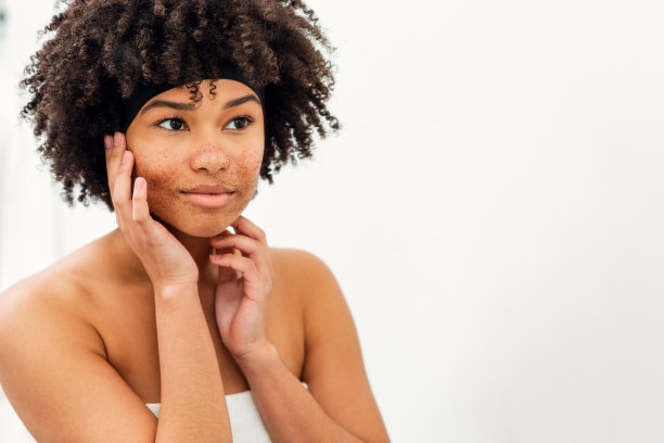 一个女人用面部磨砂膏洗脸的肖像图片下载