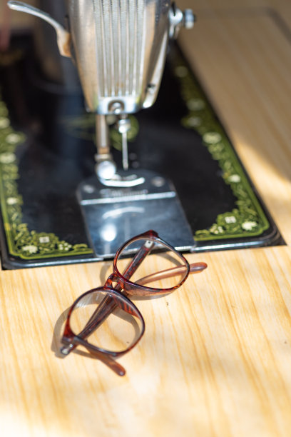 旧收音机和老花镜在缝纫机上图片下载