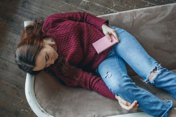 睡在沙发上的年轻女子和她的日记图片下载