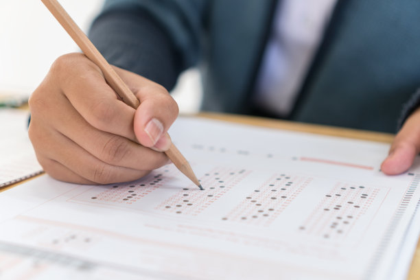 学生手执考试、书写考试、手执铅笔、带答题纸在教室里进行期末考试。教育评估的概念。软焦点图片下载