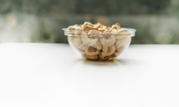 健康的食物背景图片特写腰果。坚果纹理在白色灰色的桌子上的杯子盘上的视图图片下载