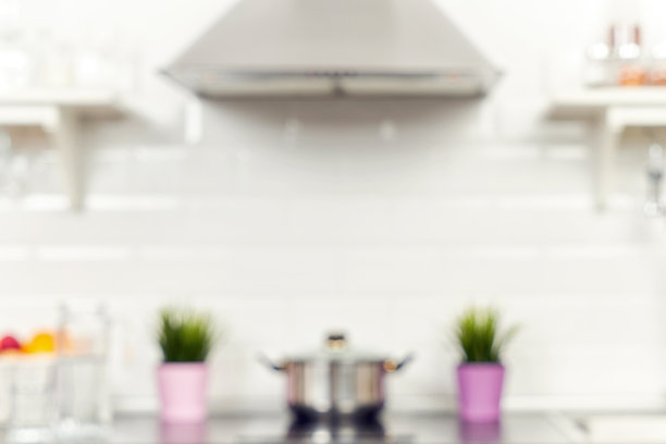 在公寓的一个照明厨房的内部。明亮的家居室内装饰项目，水果，花在一盆，钢罩。明亮的现成图片为您的个人设计图片下载