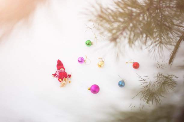冬天的照片与圣诞装饰松树。在森林里编织雪人玩具女孩站在滑雪板上。节日快乐装饰明信片。下雪的天气。图片下载