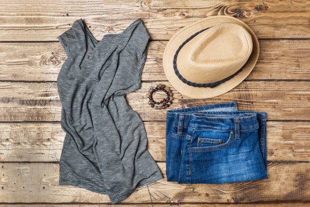 夏天女人的衣服。平铺时尚照片。蓝色牛仔裤，t恤，木制背景太阳帽。图片下载