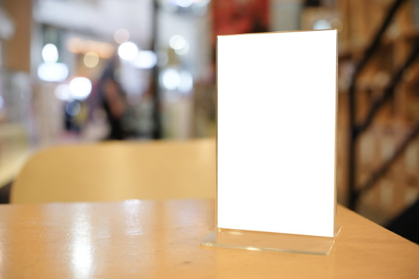 在酒吧、餐厅、咖啡厅的木桌上放置文字营销推广的菜单框空间。图片下载