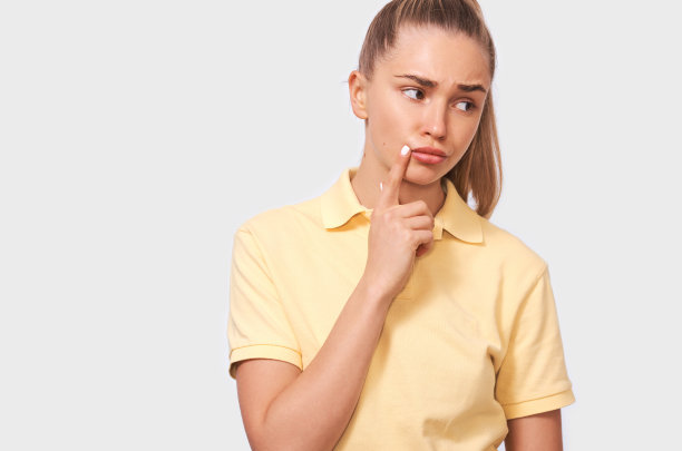 体贴的美丽的年轻女子思考和向上看。近距离的肖像，相当自信的女性，持有的手指近的脸，看认真远离摆姿势在白色的背景。人图片下载