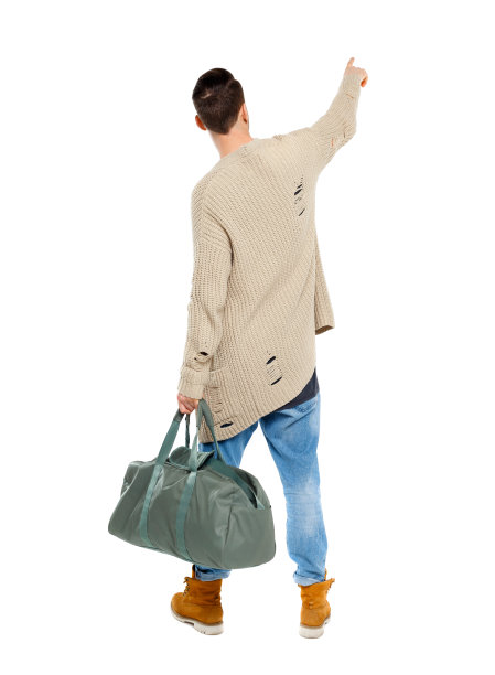 一个男人的背影，拿着一个绿色的袋子指着前方。图片下载