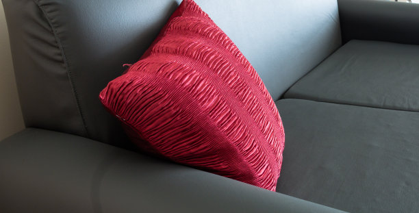 一张黑色皮沙发和红色靠垫的特写图片下载