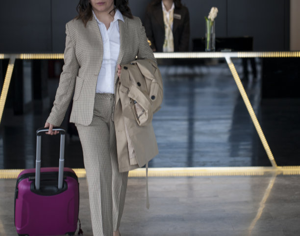 女商人拖着行李离开酒店图片下载