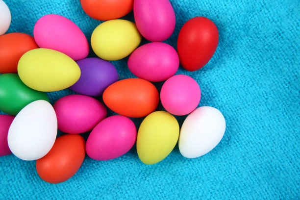 多颜色的复活节彩蛋，以明亮的蓝色羊毛毯子为背景。图片下载