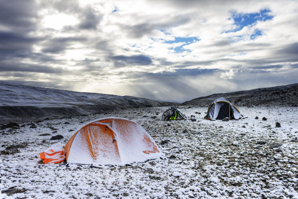 白雪覆盖的帐篷在山上，自行车在雪地里图片下载