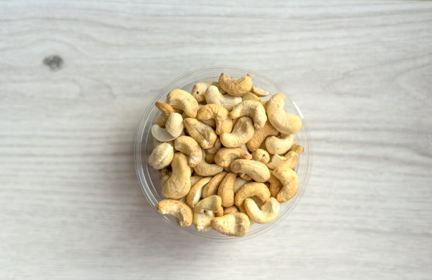 健康的食物背景图片特写腰果。坚果纹理在白色灰色的桌子上的杯子盘上的视图图片下载