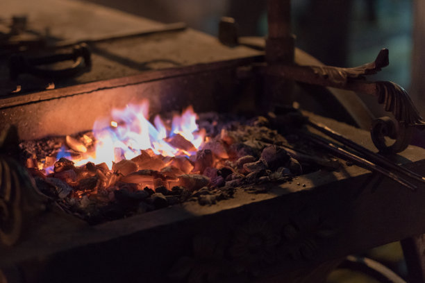 在城市的街道上，铁砧和燃烧的煤炭的形象。图片下载