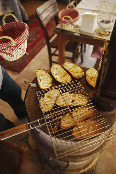 一个男人在旧炉子上烤面包图片下载