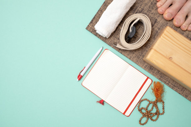 俯视图的瑜伽配件和笔记本写作。瑜伽教学课程图片下载