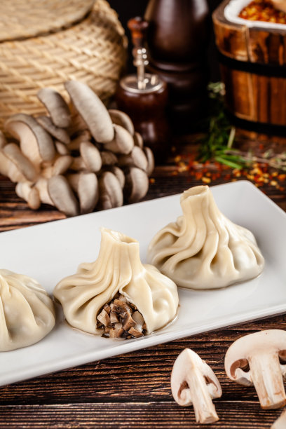 格鲁吉亚菜的概念。Khinkali是用蘑菇和白面团做成的。在格鲁吉亚餐厅里，在木桌上用白色盘子端菜。的背景图片。本空间图片下载