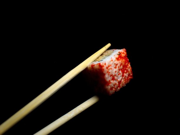 日本的食物。极简主义。食物的照片。用木筷子夹寿司。图片下载