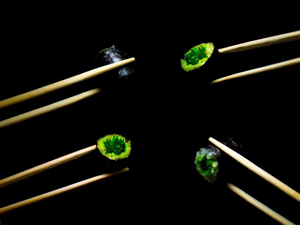 日本的食物。极简主义。食物的照片。用木筷子夹寿司。图片下载