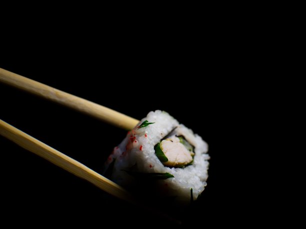 日本的食物。极简主义。食物的照片。用木筷子夹寿司。图片下载