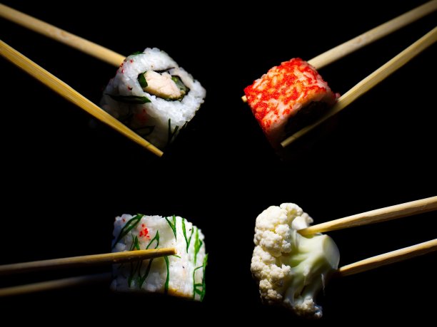 日本的食物。极简主义。食物的照片。用木筷子夹寿司。图片下载