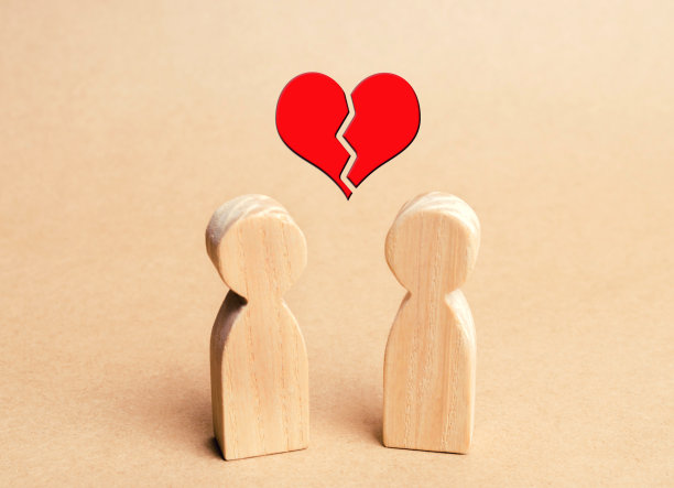 两个木雕，上面是一颗破碎的红心。分手的概念。夫妇在爱。情人。非互惠性的爱。离婚。争吵。家庭心理学。极简主义图片下载