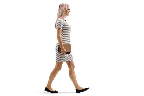 年轻的金发女人走路拿着书图片下载