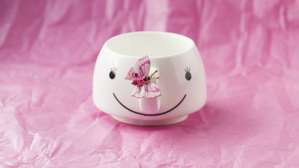 美丽的粉红色背景与白色的杯子和粉红色的蝴蝶图片下载