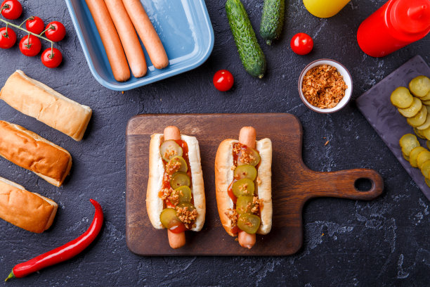 图片上是桌子上的切菜板上的两个热狗图片下载