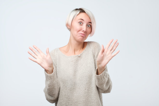 女人举手投降，傻笑着看着镜头，不参与图片下载