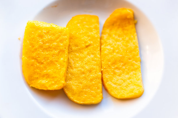 玉米粥黄橙色的玉米饼油炸平顶视图上面下在餐厅的白色盘子上开胃金黄色图片下载