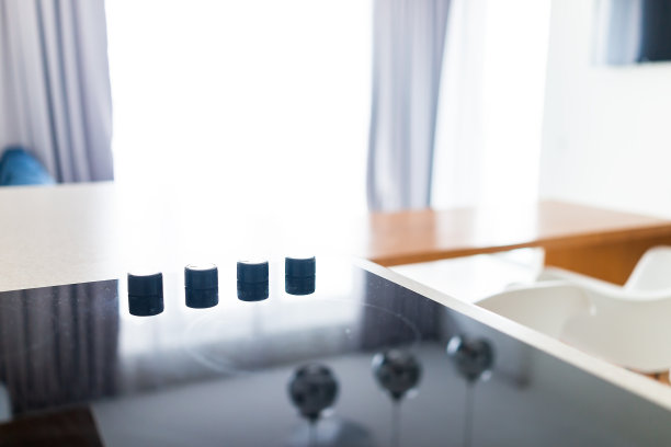 在空荡荡的家里，现代豪华电炉顶部灶顶玻璃反射和圆圈背景旋钮的特写图片下载