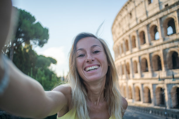 一名年轻女子在罗马享受意大利旅行的自拍，并在著名的罗马斗牛场前拍摄了一张照片图片下载