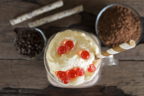 从俯视图看，巧克力和可可与牛奶冰沙混合在木质背景上。图片下载