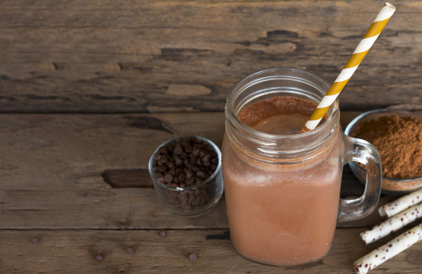 巧克力和可可与牛奶冰沙混合在木地板上。图片下载