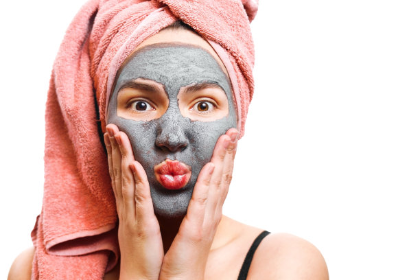 皮肤女人的面具，有趣和快乐的女孩与面膜在一个白色的背景，孤立的照片，女孩吹她的嘴唇图片下载