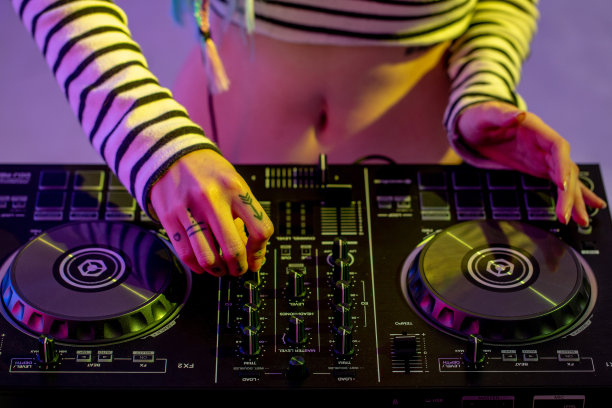 亚洲女孩DJ正在播放一个转盘，在晚会是丰富多彩的。图片下载