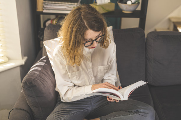 在沙发上看书的女人图片下载