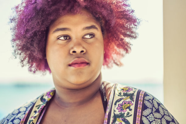 年轻的非洲裔美国女性，紫色头发，远离镜头。图片下载