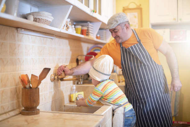 父亲和儿子在厨房。图片下载