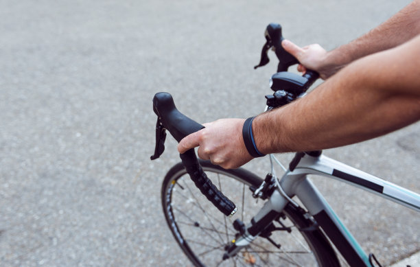 一名男子戴着运动追踪器，紧握着赛车的车把图片下载