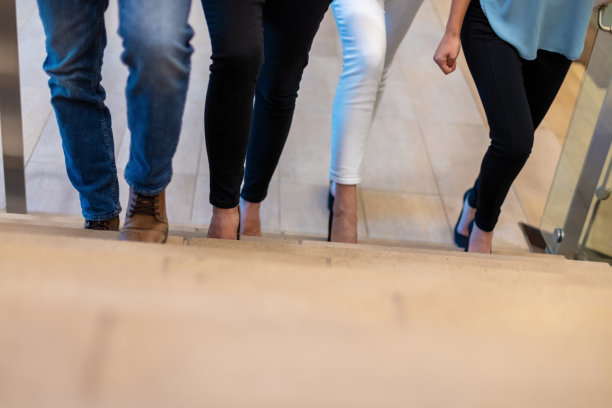 男性和女性商务办公室工作人员走过工作空间的走廊和楼梯图片下载