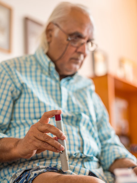 成熟的男人在家拿着注射笔图片下载