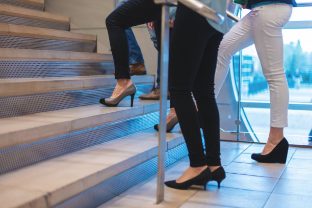 男性和女性商务办公室工作人员走过工作空间的走廊和楼梯图片下载