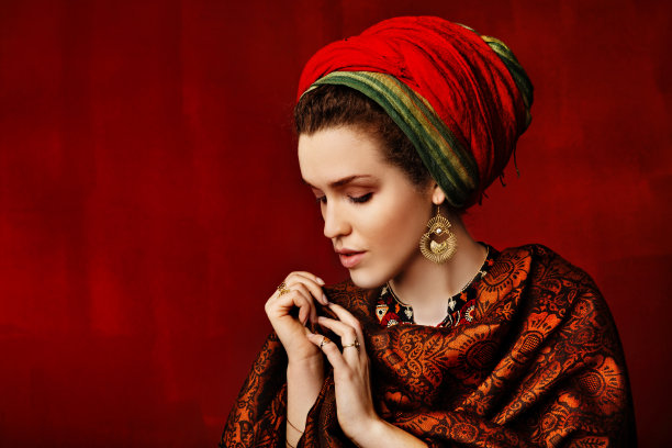 一个带装饰品的女孩的肖像。亮红色的衣服图片下载