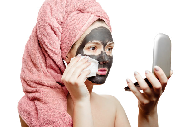 漂亮的性感女人木炭面膜擦木炭面膜从脸与餐巾图片下载