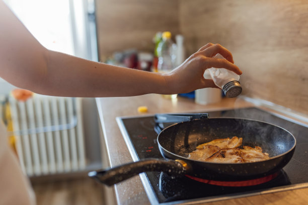 女人煮鸡肉，调味图片下载