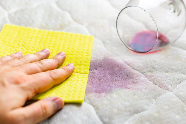 用海绵清洗酒渍。酒洒在白色的床单上。葡萄酒杯。不幸,不幸的情况。图片下载