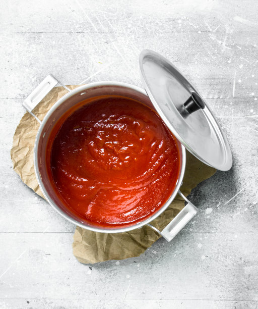 番茄酱放在纸上的锅里。图片下载
