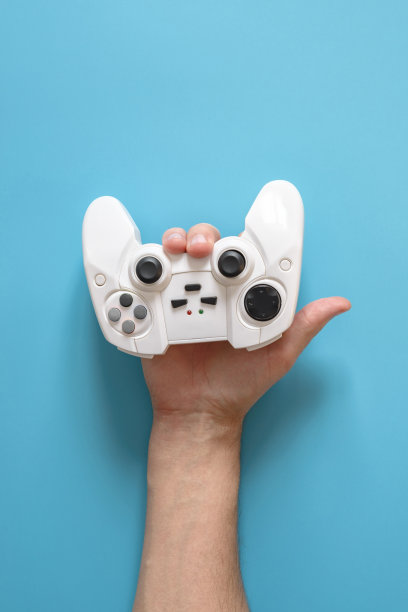 一个男人的手握着一个白色的操纵杆，就像一个喇叭的标志。蓝色的坚实的背景。图片下载