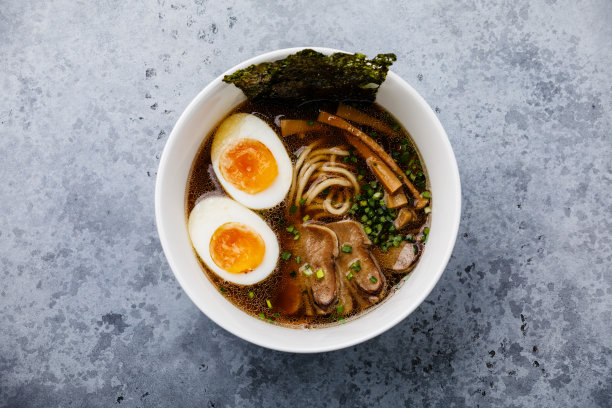 亚洲拉面肉汤牛肉舌肉和Ajitama腌制鸡蛋在碗混凝土背景图片下载